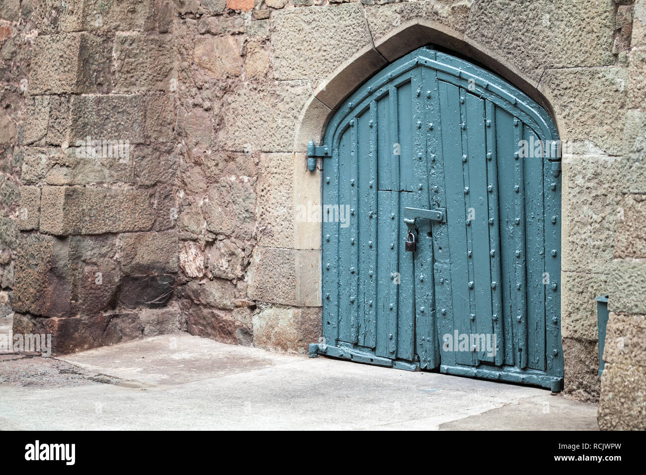 Blue locked gate in old stone wall, ancient Arabic style architecture Stock Photo