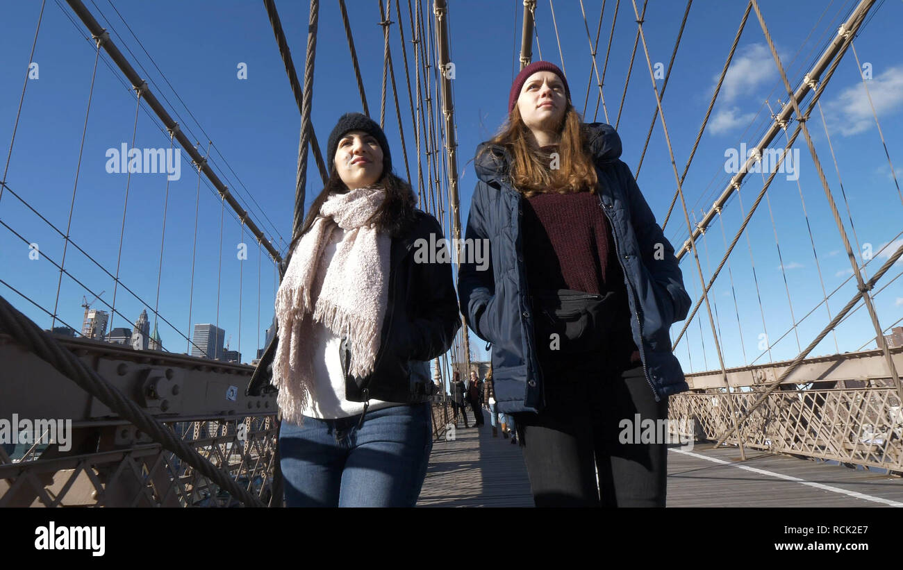 Two girls walk over the famous Brooklyn Bridge in New York Stock Photo Alamy