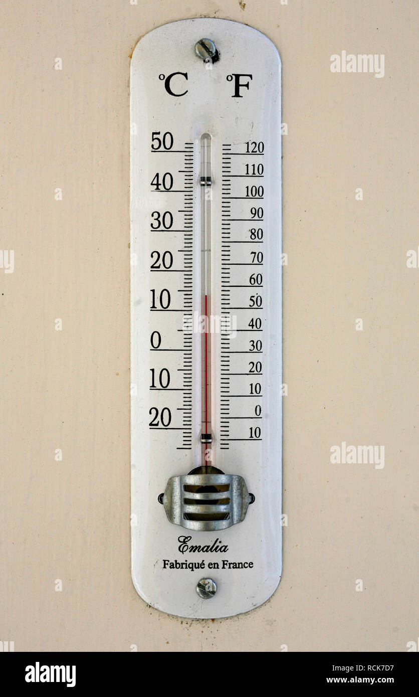 THERMOMETER with Celsius and Fahrenheit degrees on wall Stock Photo