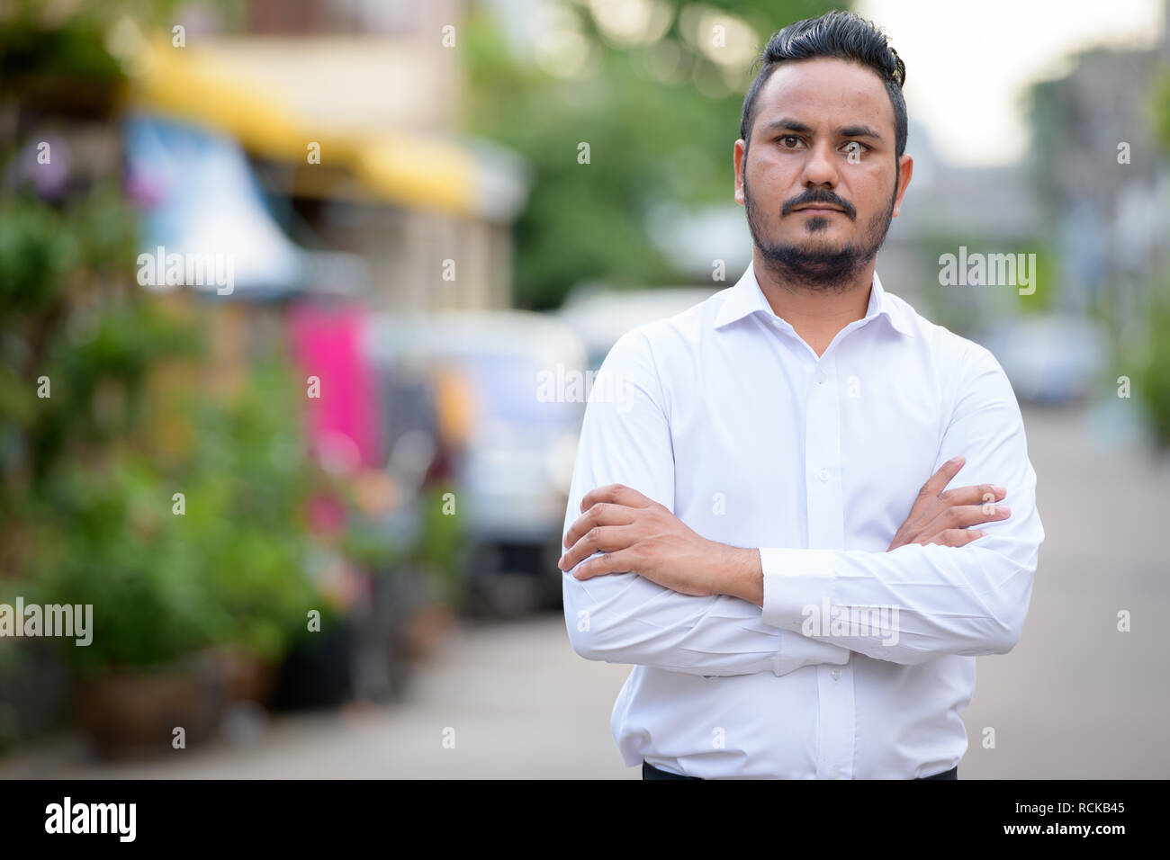 Bearded Indian businessman with arms crossed outdoors Stock Photo - Alamy