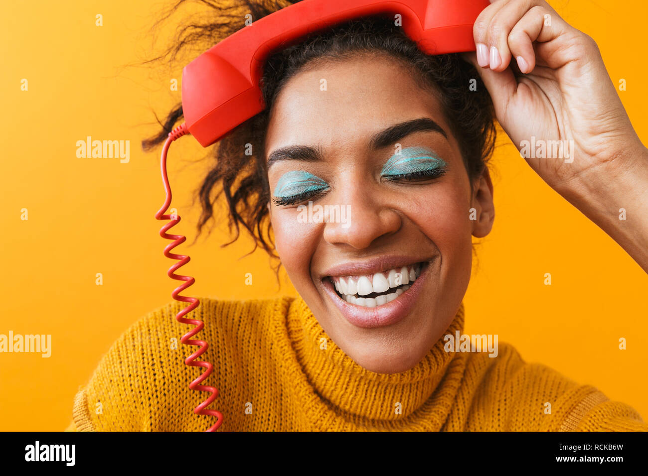 Portrait Of Crazy African American Woman With Afro Hairstyle Laughing And Holding Red Handset Isolated Over Yellow Background Stock Photo Alamy
