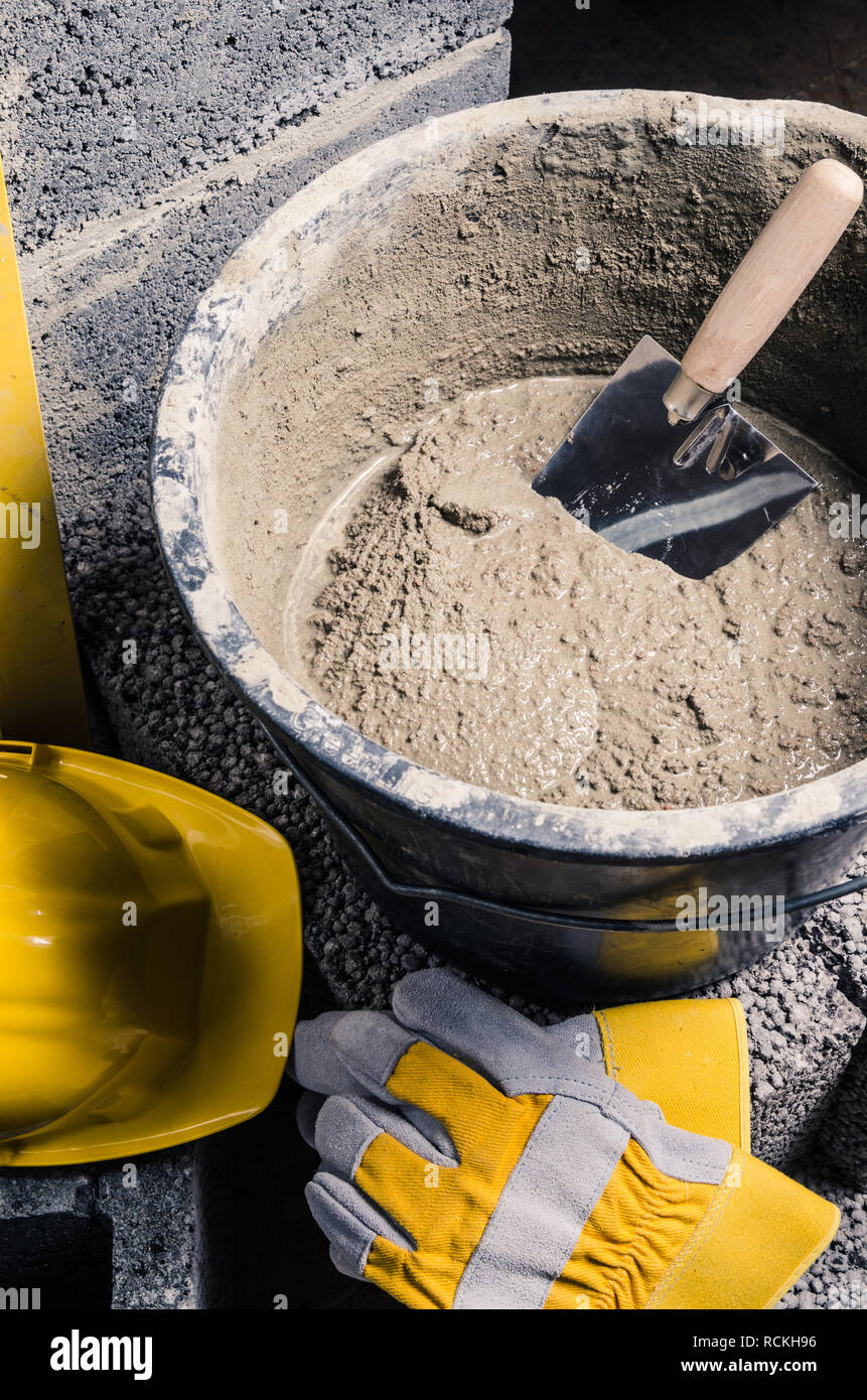 Tools for bricklayer bucket with a solution and a trowel, close-up Stock Photo