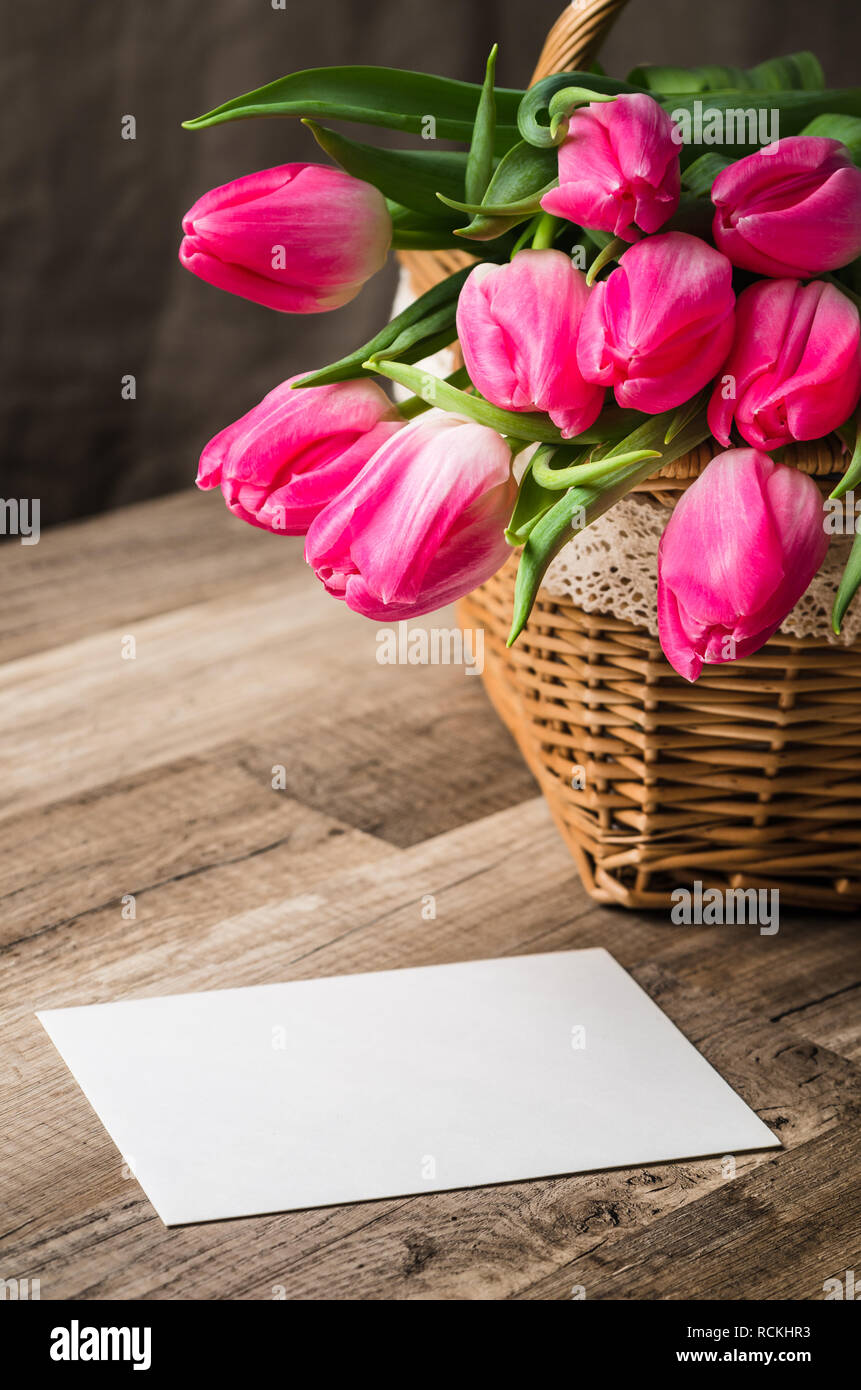 Beautiful bouquet of pink tulips and congratulations on the table Stock Photo