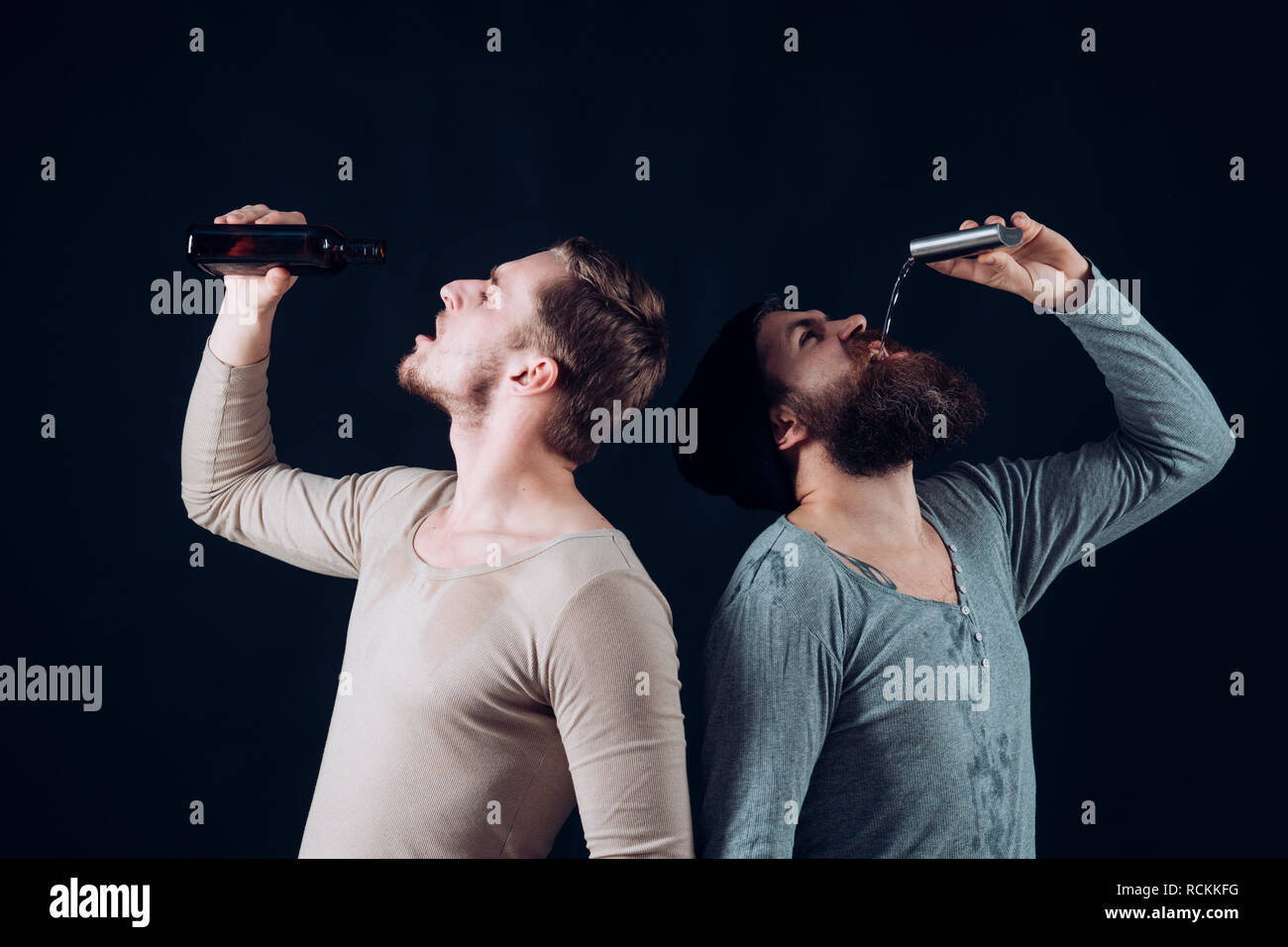 Drunkenness. Alcohol addicts. Men drinking alcohol from bottle and ...