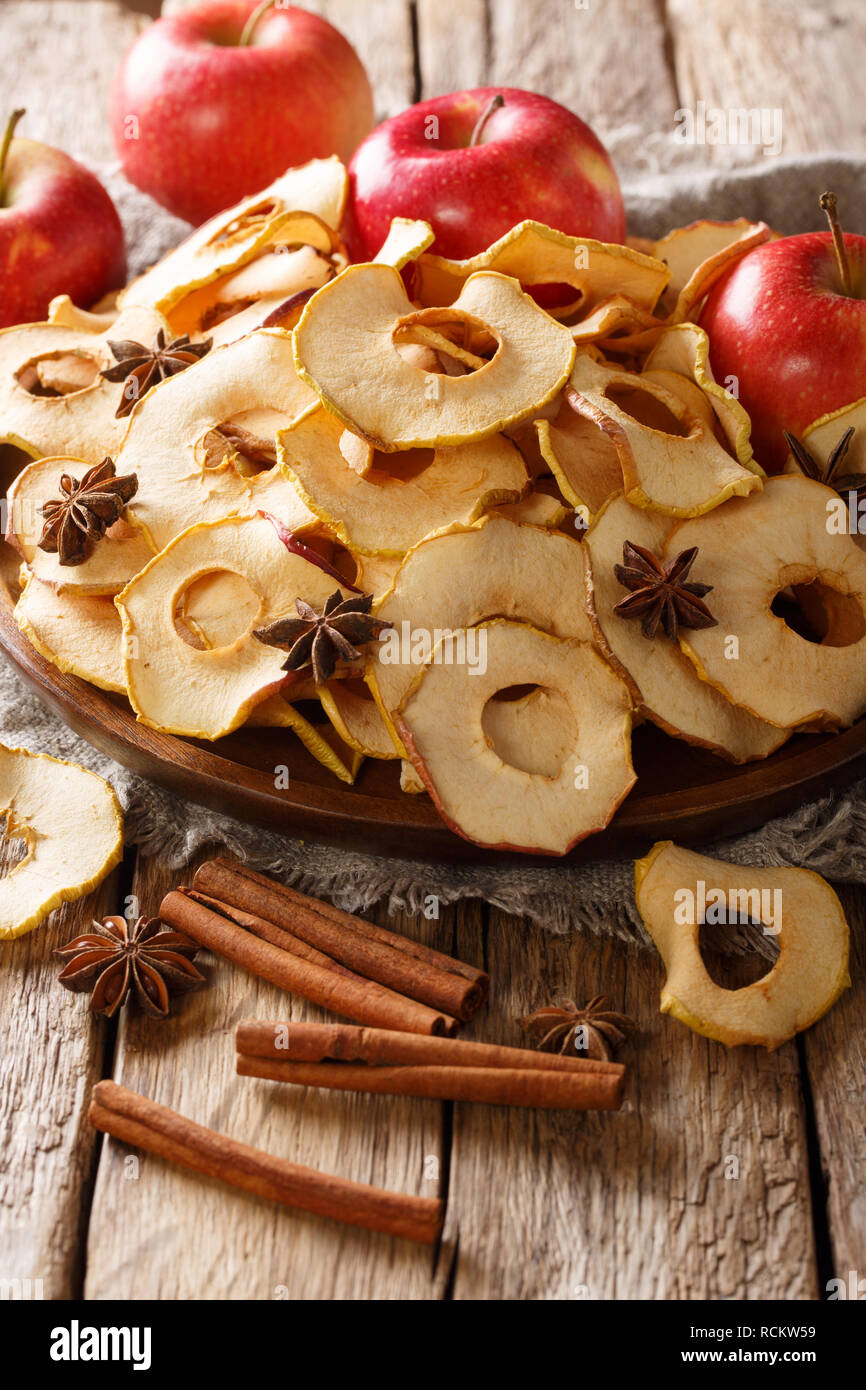 Sweet apple chips with cinnamon and star anise closeup on a plate on the table. vertical Stock Photo