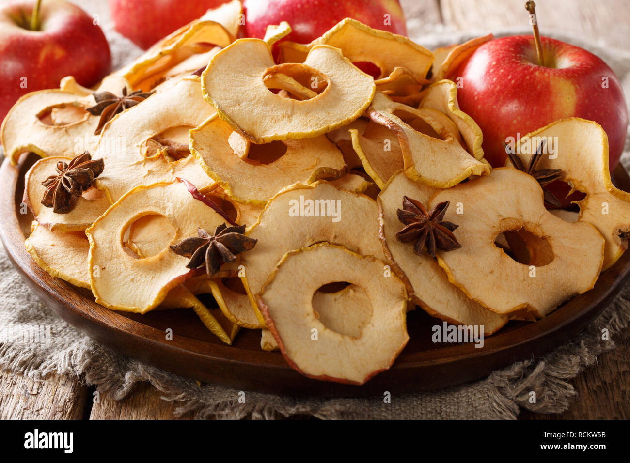 Apple chips with cinnamon and star anise close-up on a plate on the table. horizontal Stock Photo
