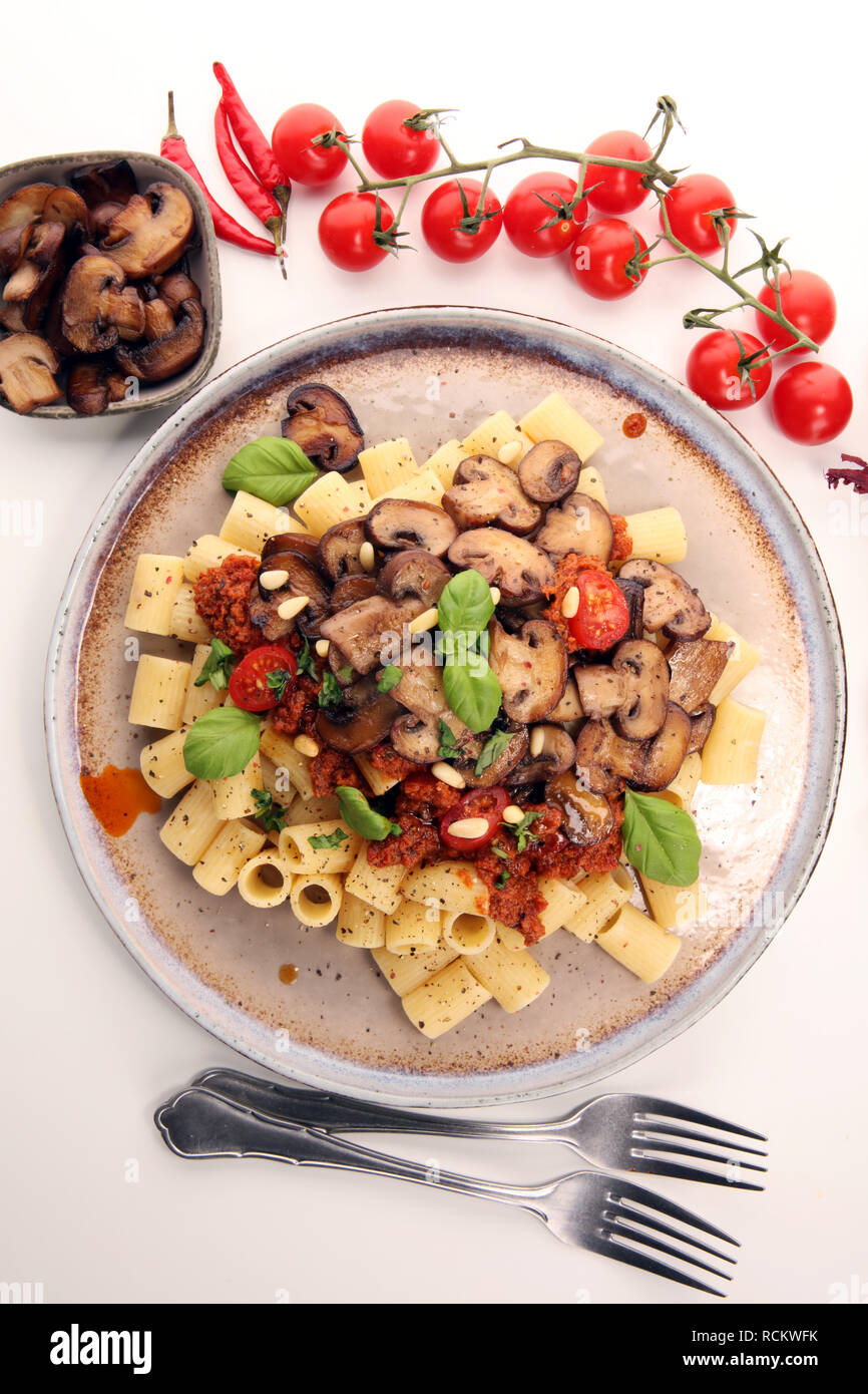 Penne pasta rigatoni in tomato sauce with mushrooms, tomatoes decorated