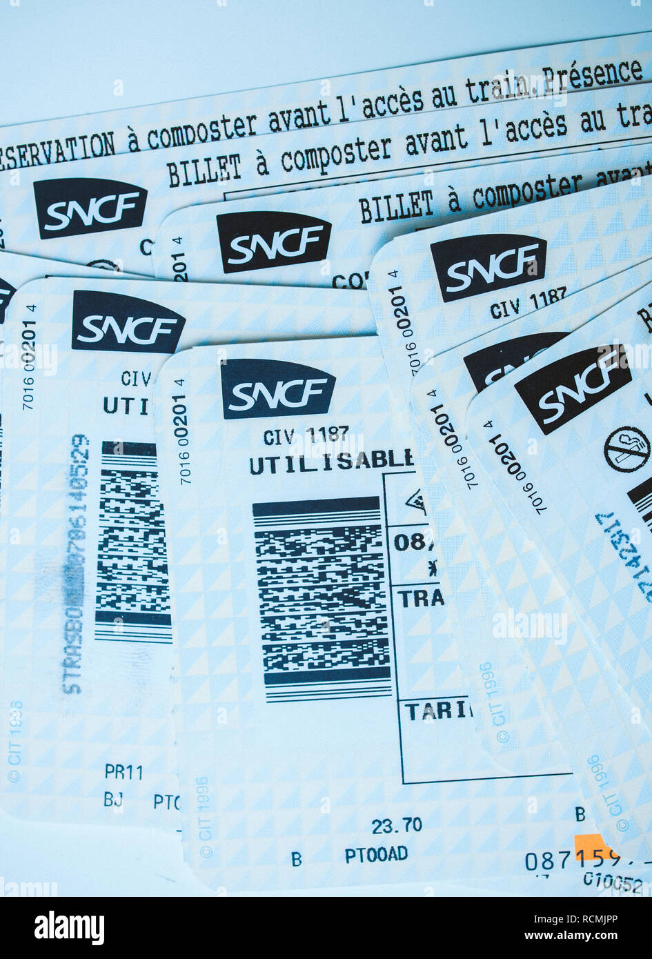 PARIS, FRANCE - JAN 14, 2015: Stack of multiple SNCF (Societe nationale des chemins de fer francais) train tickets seen from above randomly arranged on a table blue tint  Stock Photo