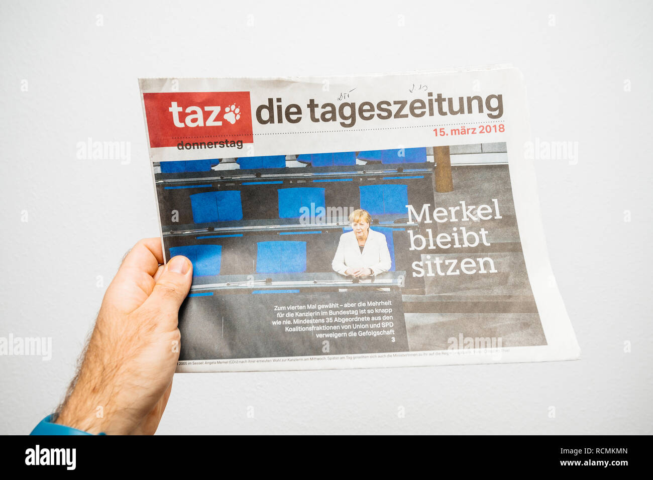 PARIS, FRANCE - MAR 19, 2017: Man reading German die tageszeitung newspaper at press kiosk featuring Angela Dorothea Merkel re election as Chancellor of Germany Stock Photo