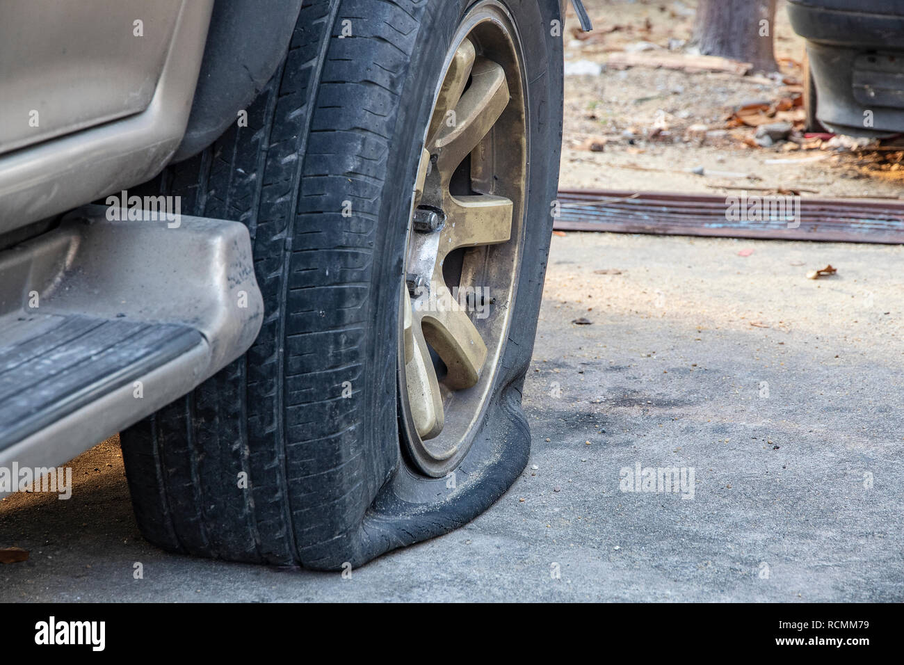 Close-up of damaged flat tire of  car on parking. Stock Photo