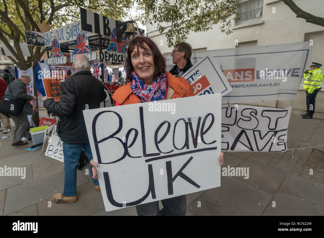London, UK. 15th January 2019. A woman holds a poster 'BeLeave UK'. Groups against leaving the EU, including SODEM, Movement for Justice and In Limbo and Brexiteers Leave Means Leave and others protest opposite Parliament as Theresa May's Brexit deal was being debated.  While the two groups mainly kept apart, a small group, some in yellow jackets came to shout insults at pro-EU campaigners, while police tried to keep the two groups separate. Credit: Peter Marshall/Alamy Live News Stock Photo
