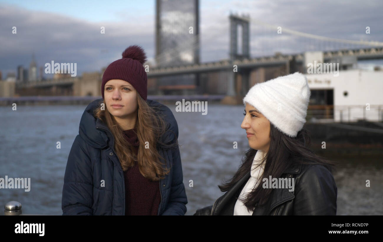 Two friends travel to New York for sightseeing at Brooklyn Bridge Stock