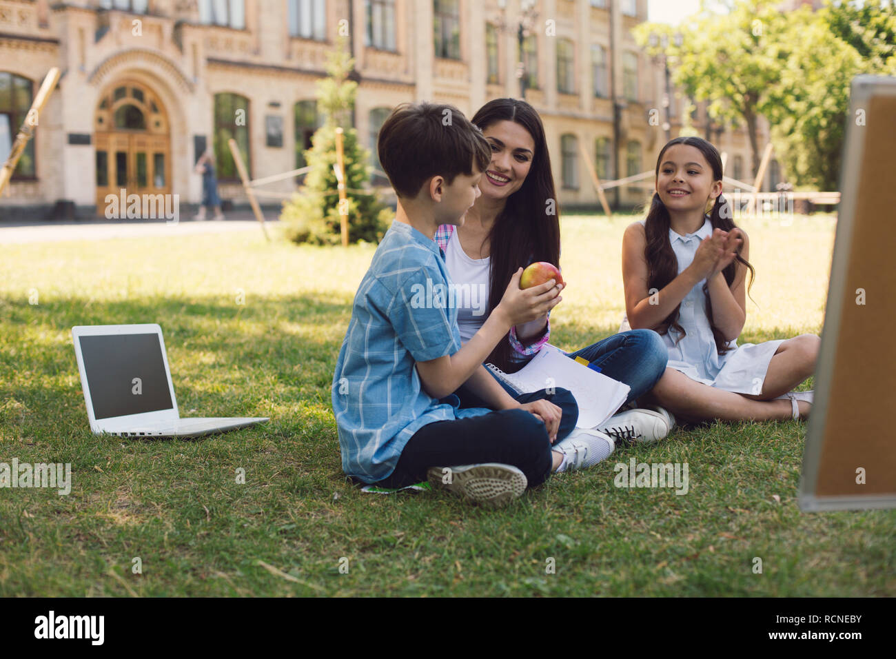 Teacher giving apple to kid Stock Photo