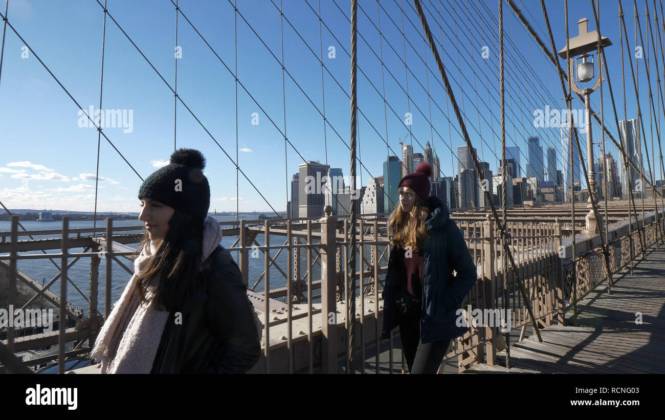 Two friends in New York walk over the famous Brooklyn Bridge Stock Photo Alamy