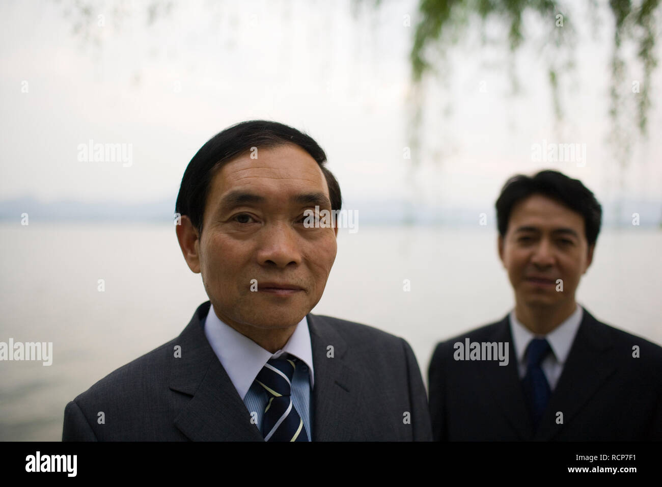 Portrait of a mid-adult businessman standing outdoors with a colleague. Stock Photo