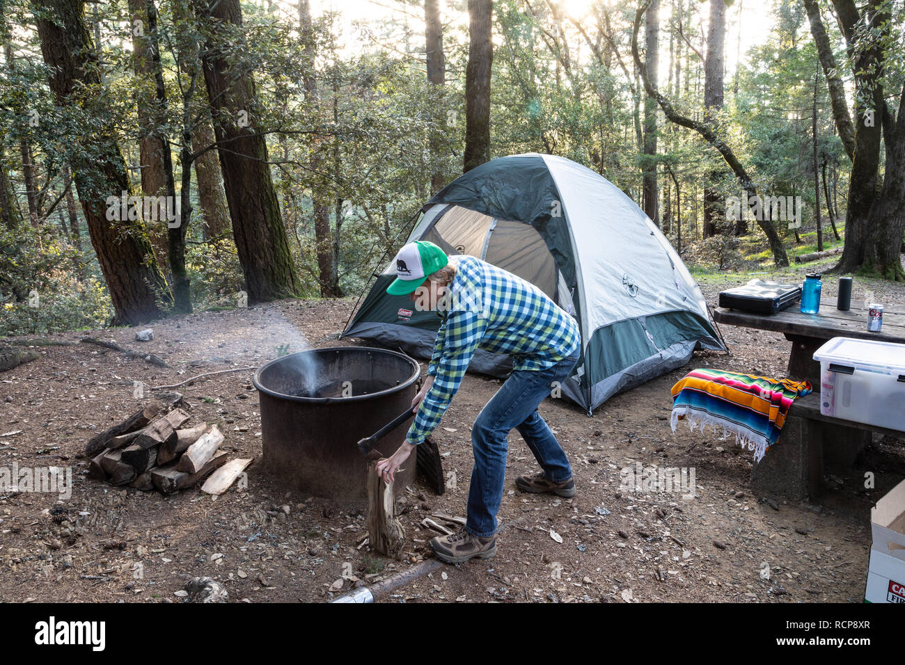 A camper splits kindling to start a camp fire at Pantoll Campground in Mount Tamalpais State Park, California. Stock Photo