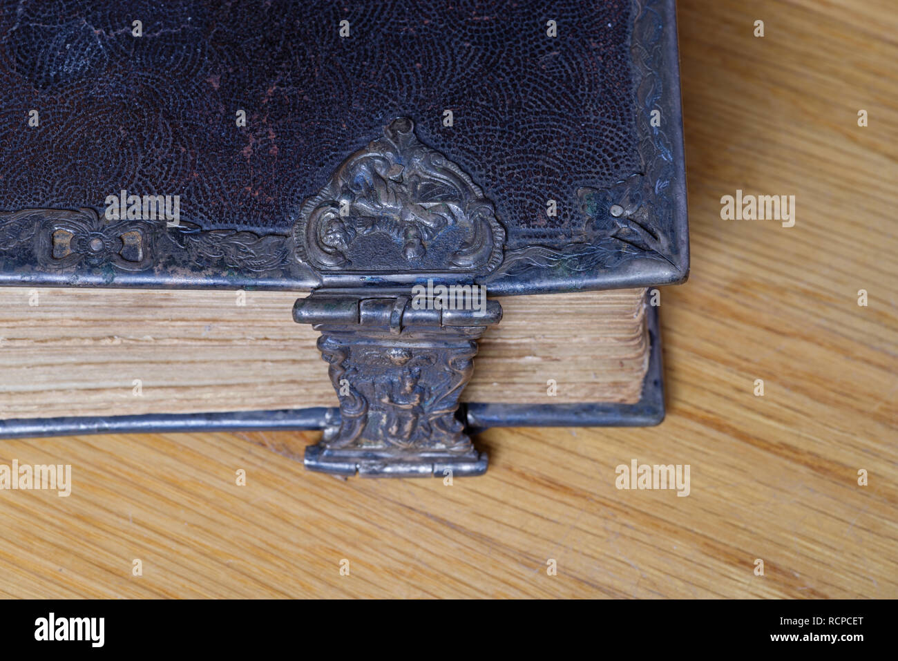 corner of old bible with metal clasp on wood Stock Photo