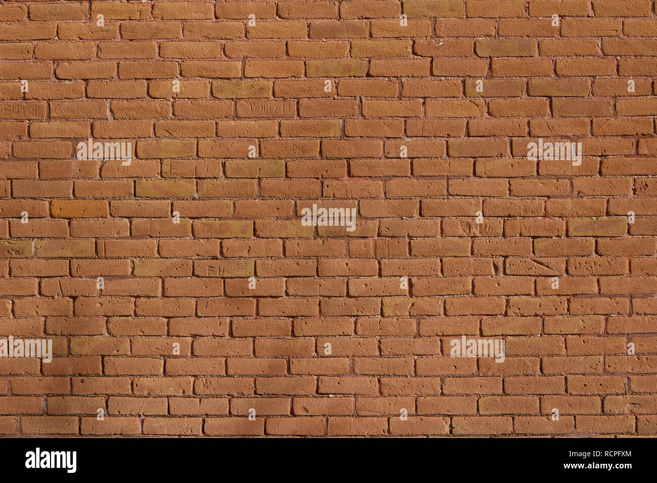 Antique weathered brick wall background abstract with deteriorating red clay bricks in traditional running bond pattern Stock Photo