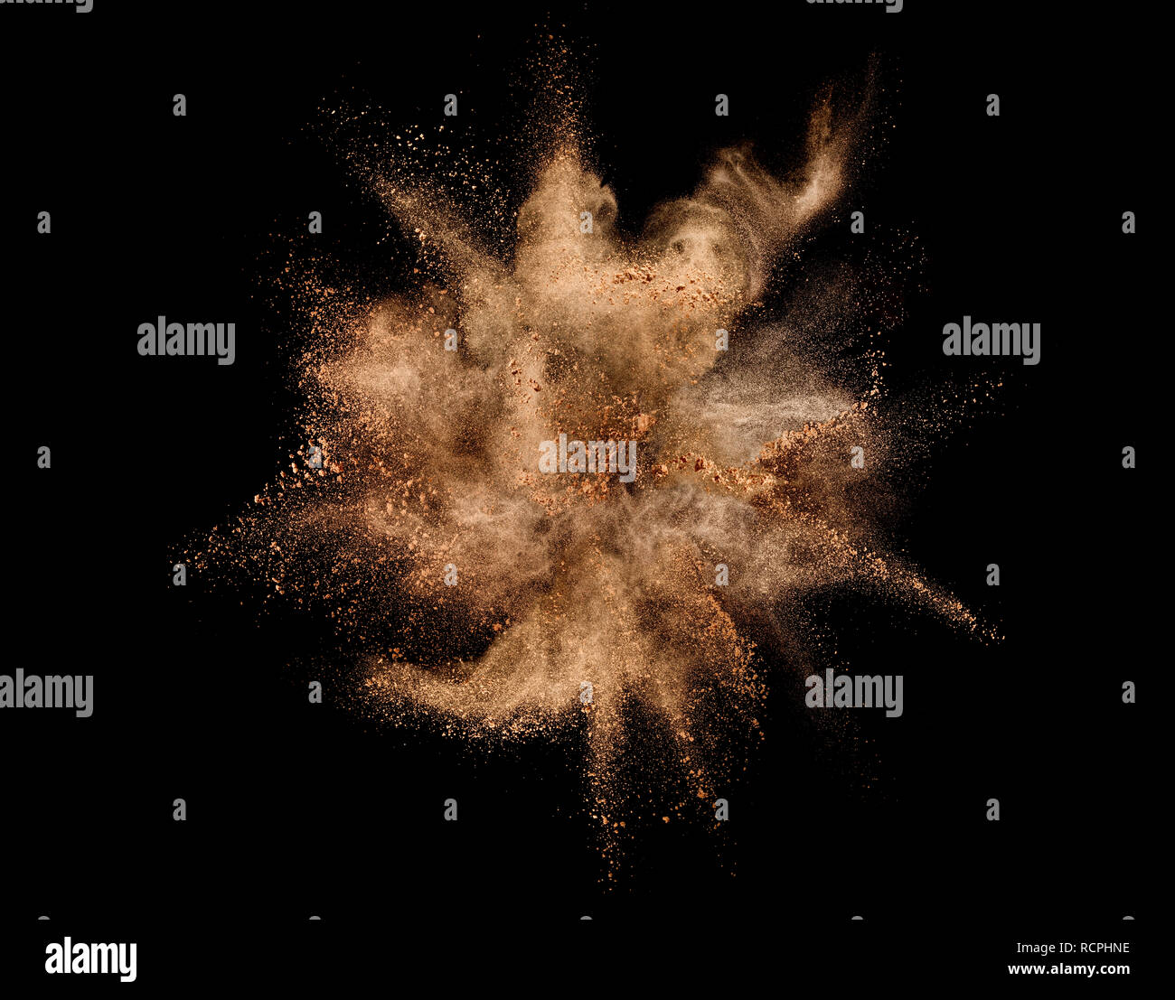 Explosion of brown powder on black background. Stock Photo
