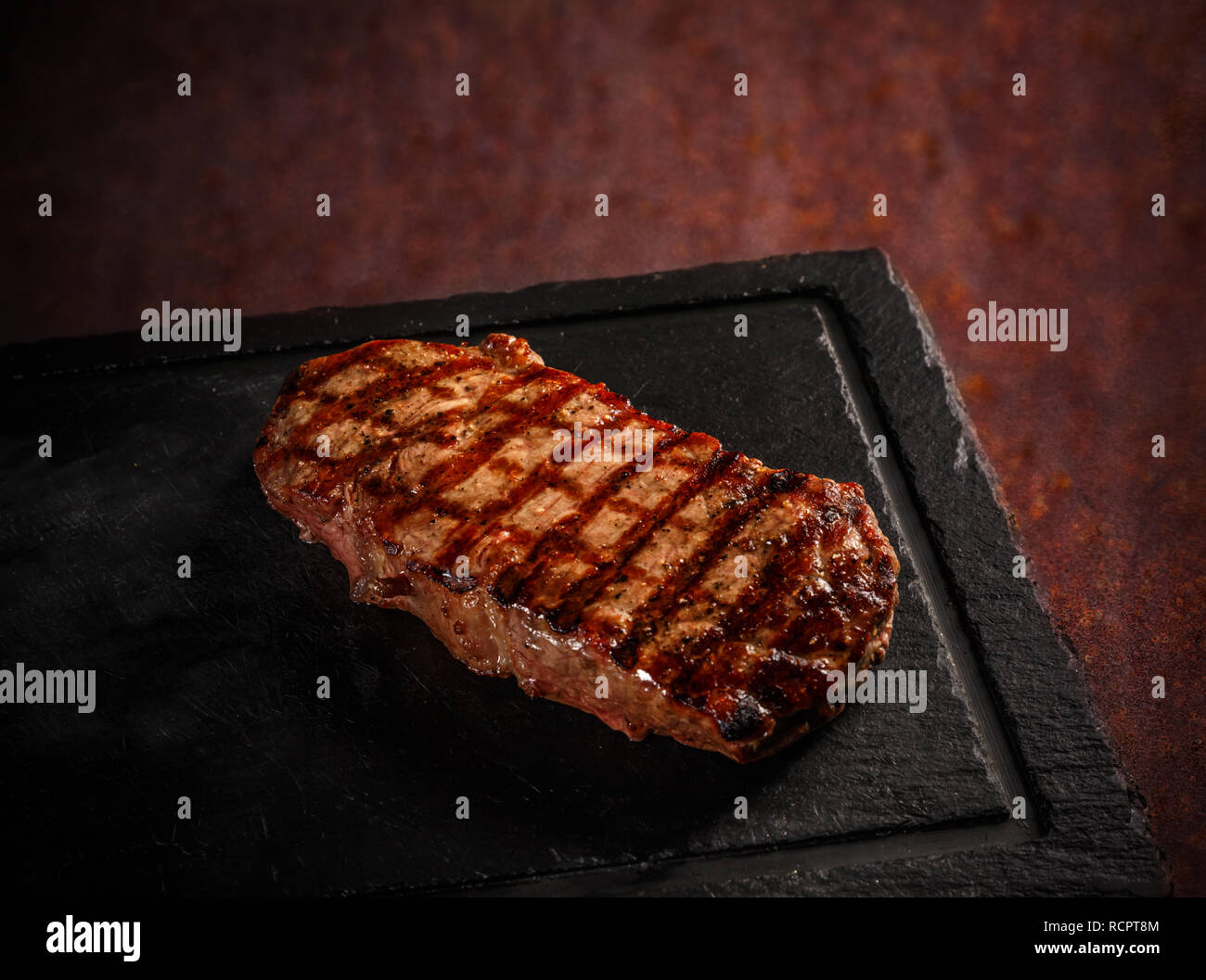 Maturated Argentinian sirloin steak on black slate board Stock Photo
