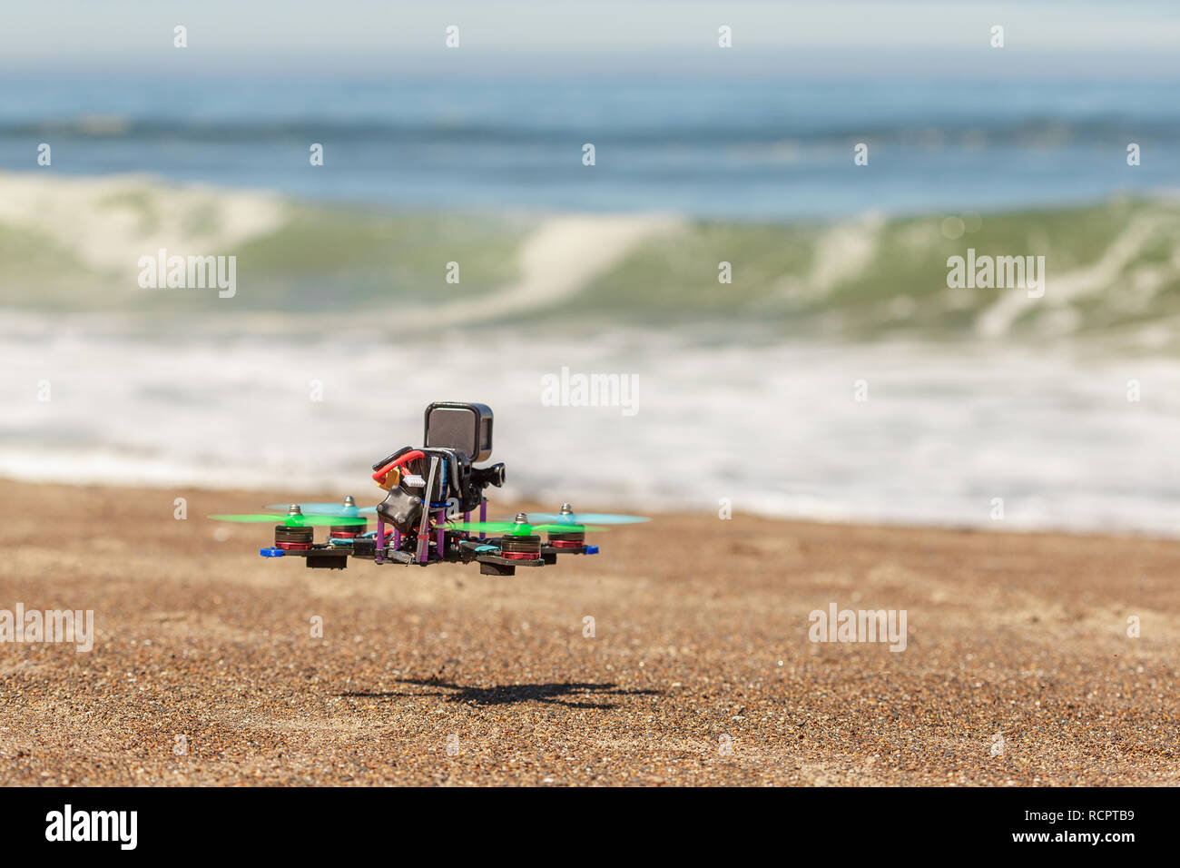 Small quadrocopter, copter, drone with mounted action camera flying on