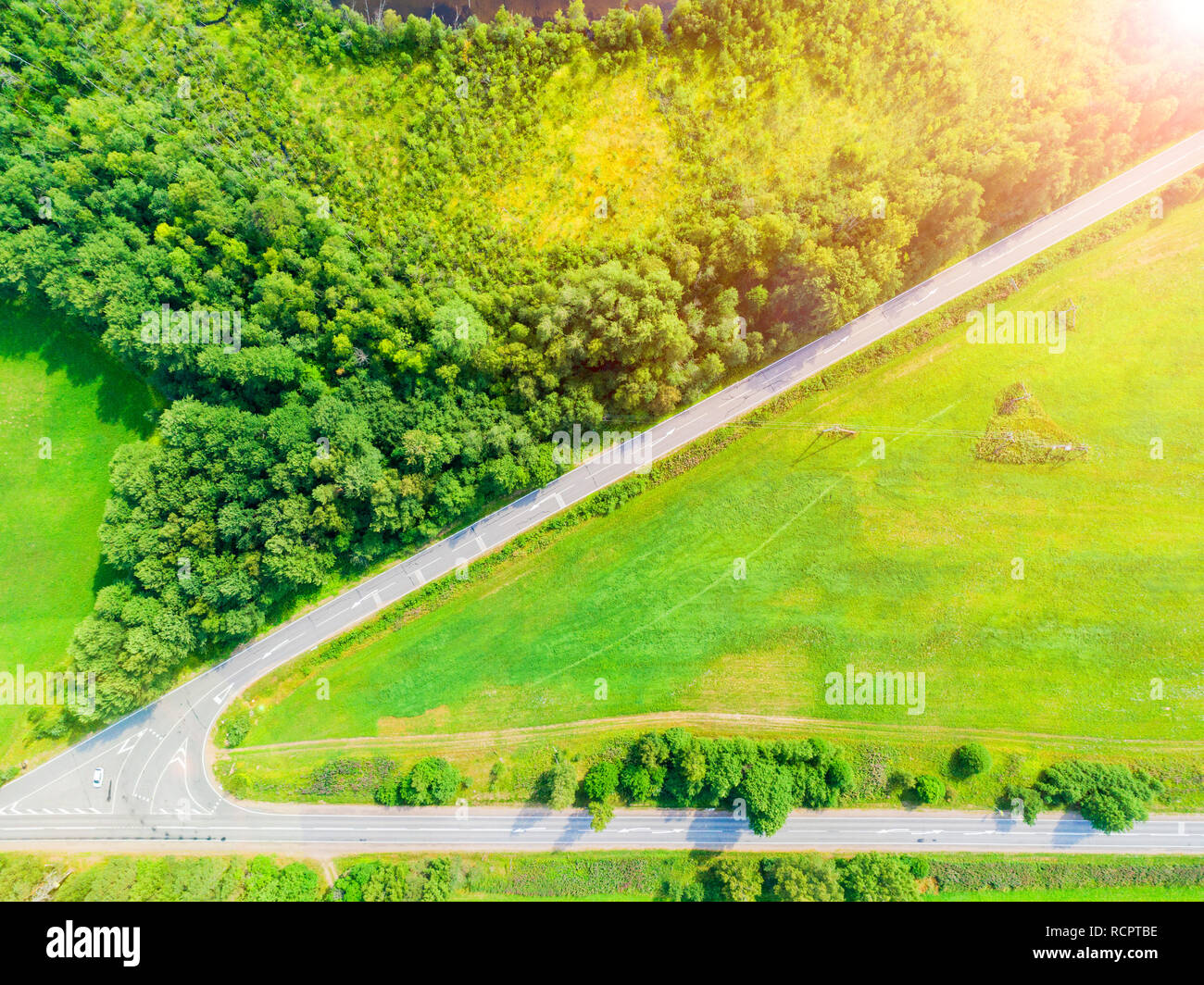 Aerial view of a country road in the forest with moving cars. Landscape ...
