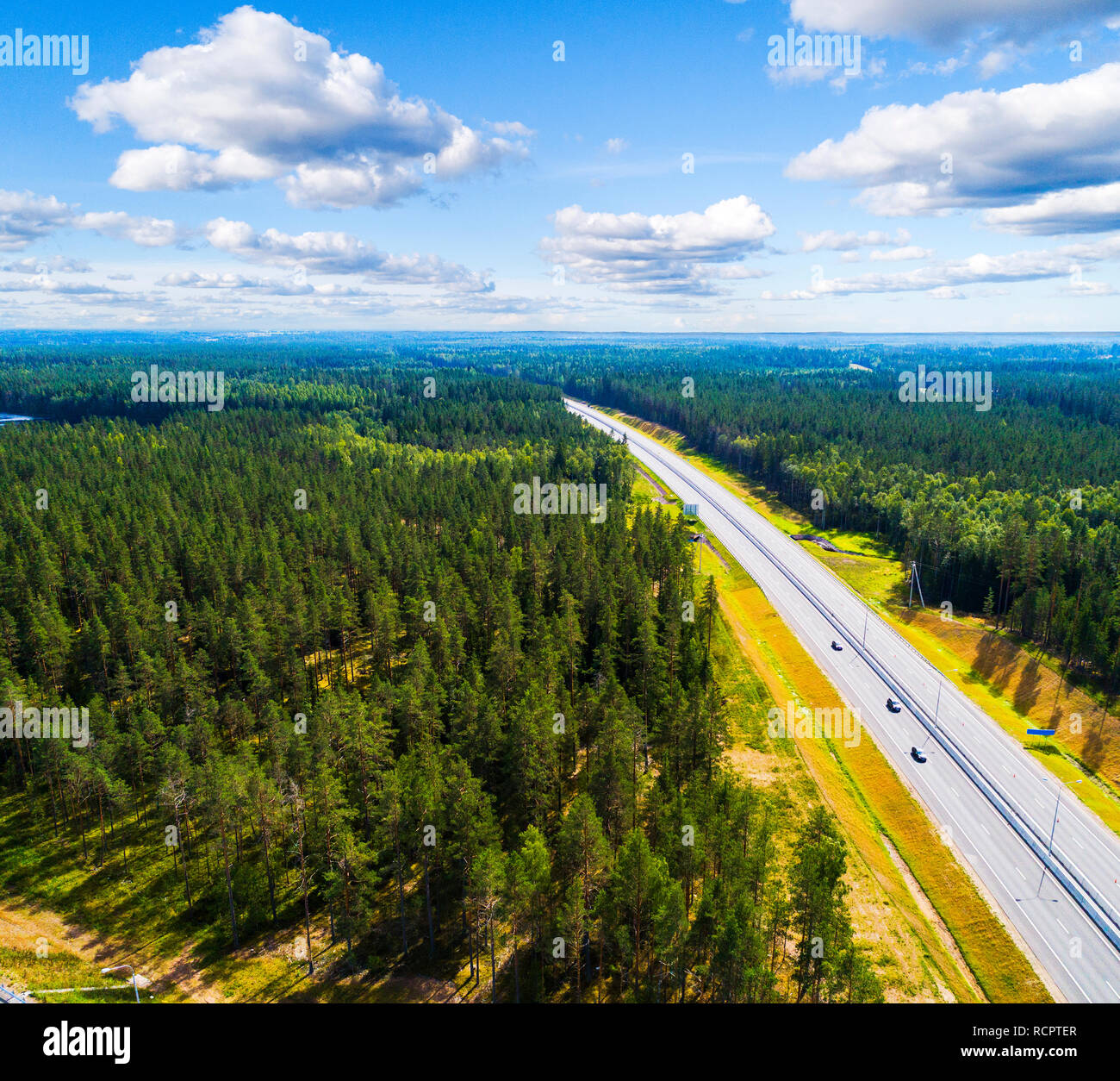 Aerial view of a country road in the forest with moving cars. Landscape ...