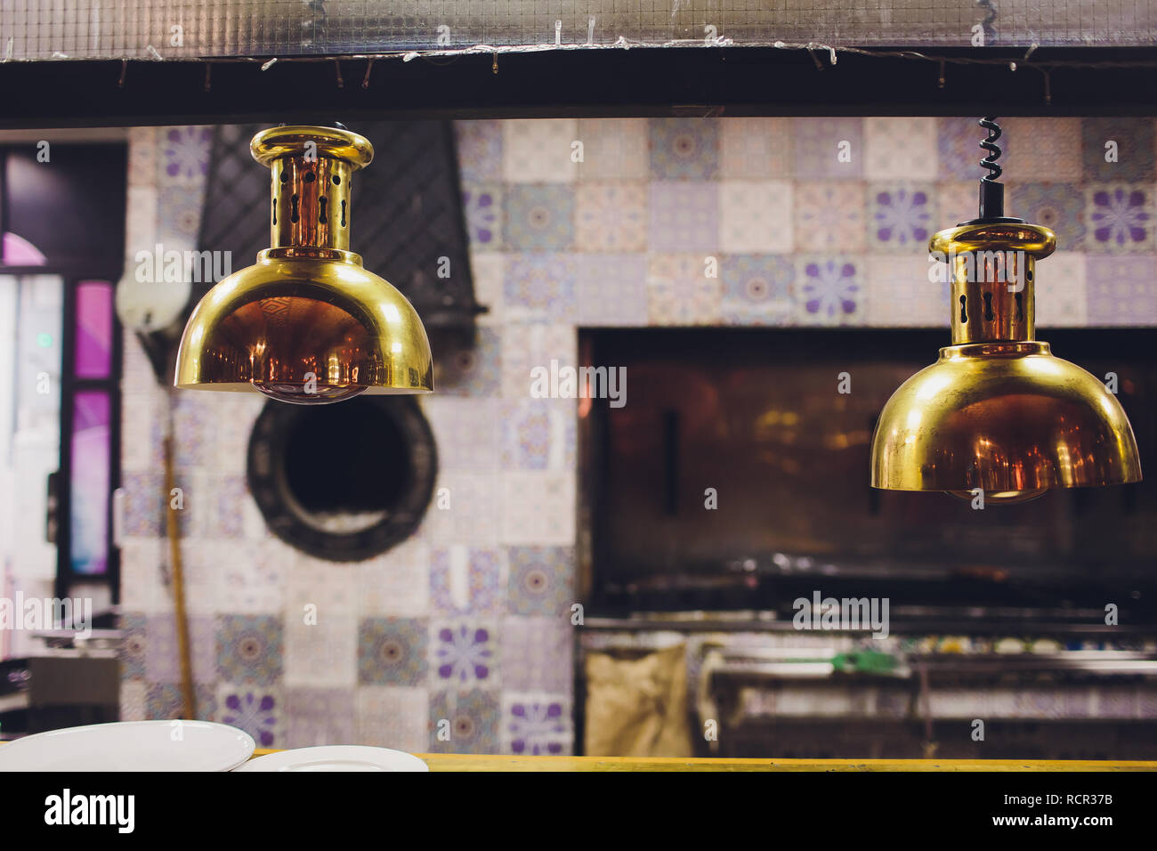 Ham meat carving on cutting board with condiments under heat lamp at