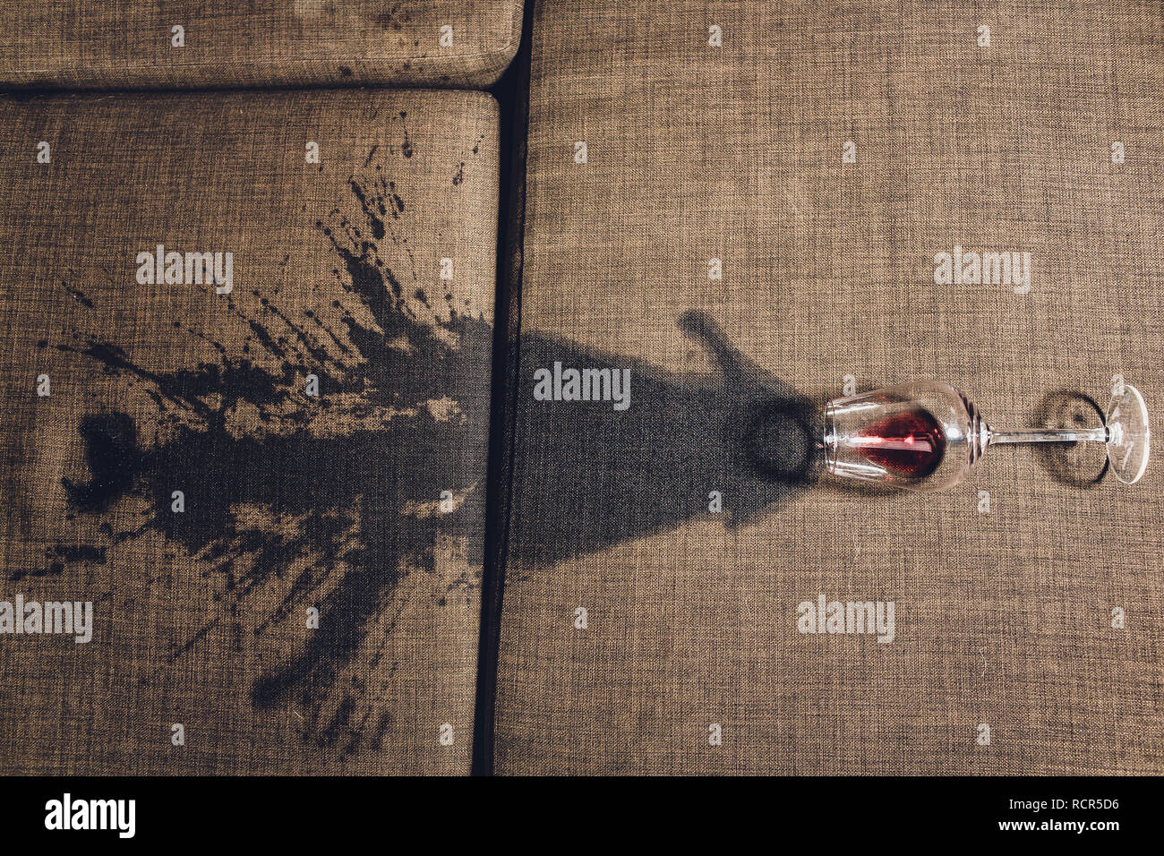 Red wine spilled on a grey couch sofa Stock Photo - Alamy