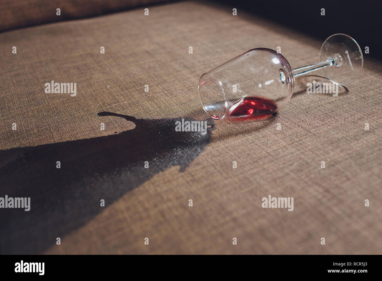 Red wine spilled on a grey couch sofa Stock Photo Alamy
