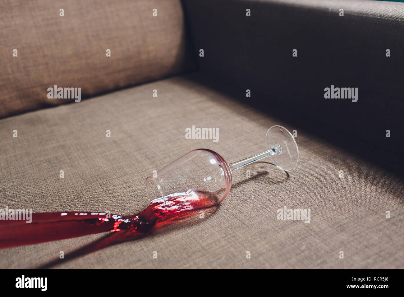 Red wine spilled on a grey couch sofa Stock Photo - Alamy