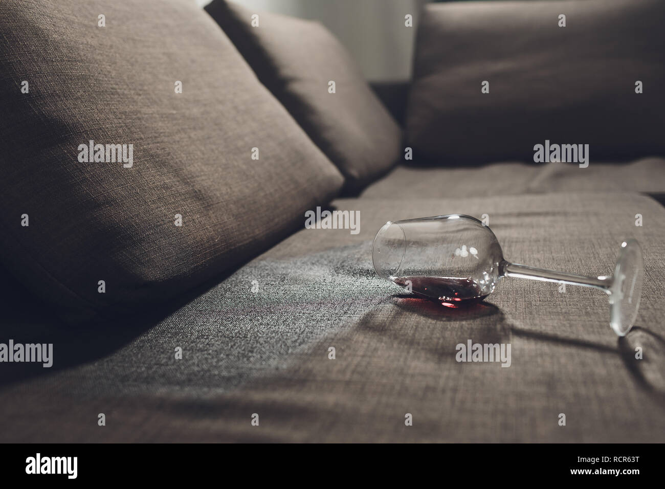 Red wine spilled on a grey couch sofa Stock Photo - Alamy