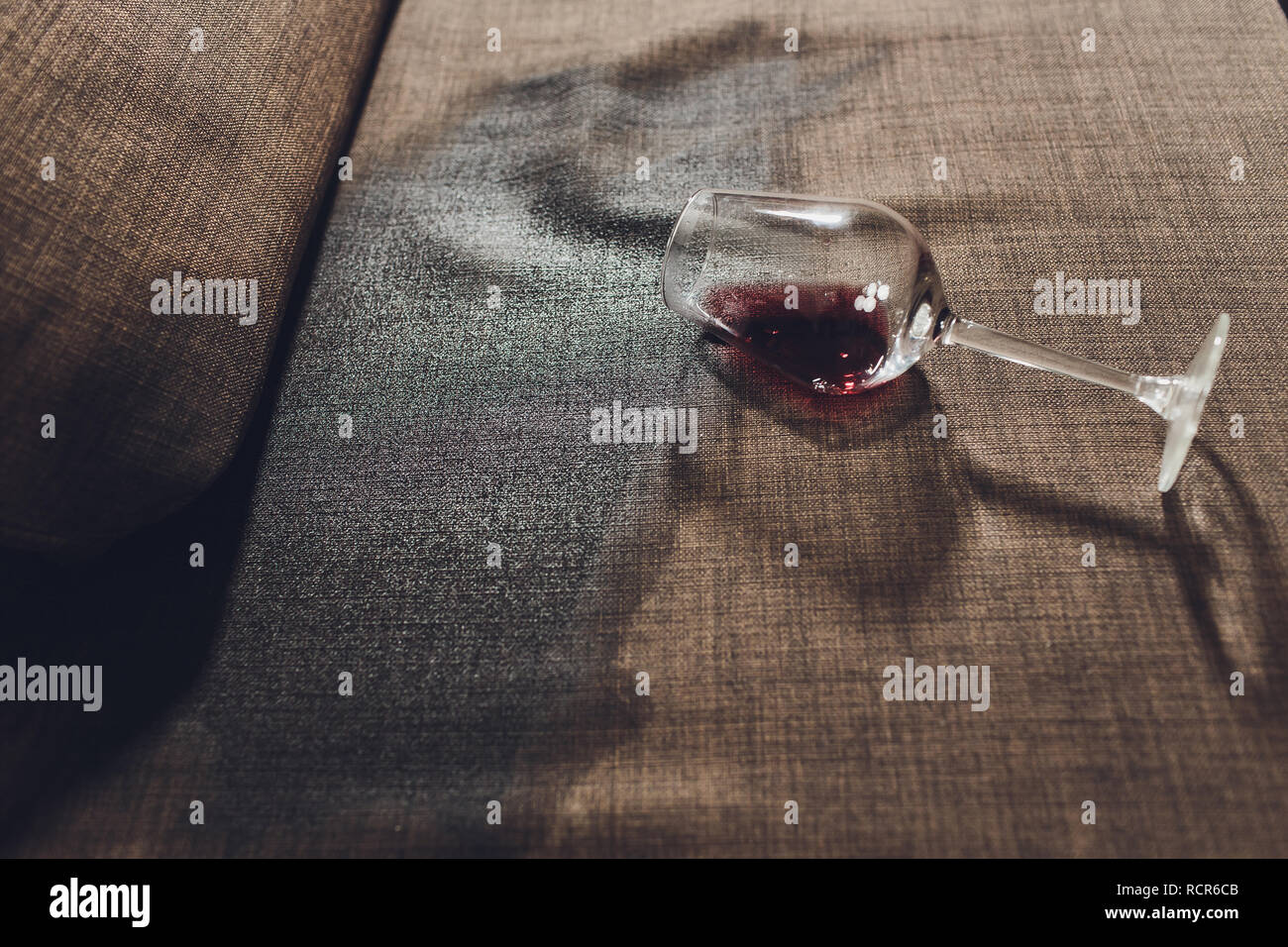 Red wine spilled on a grey couch sofa Stock Photo Alamy