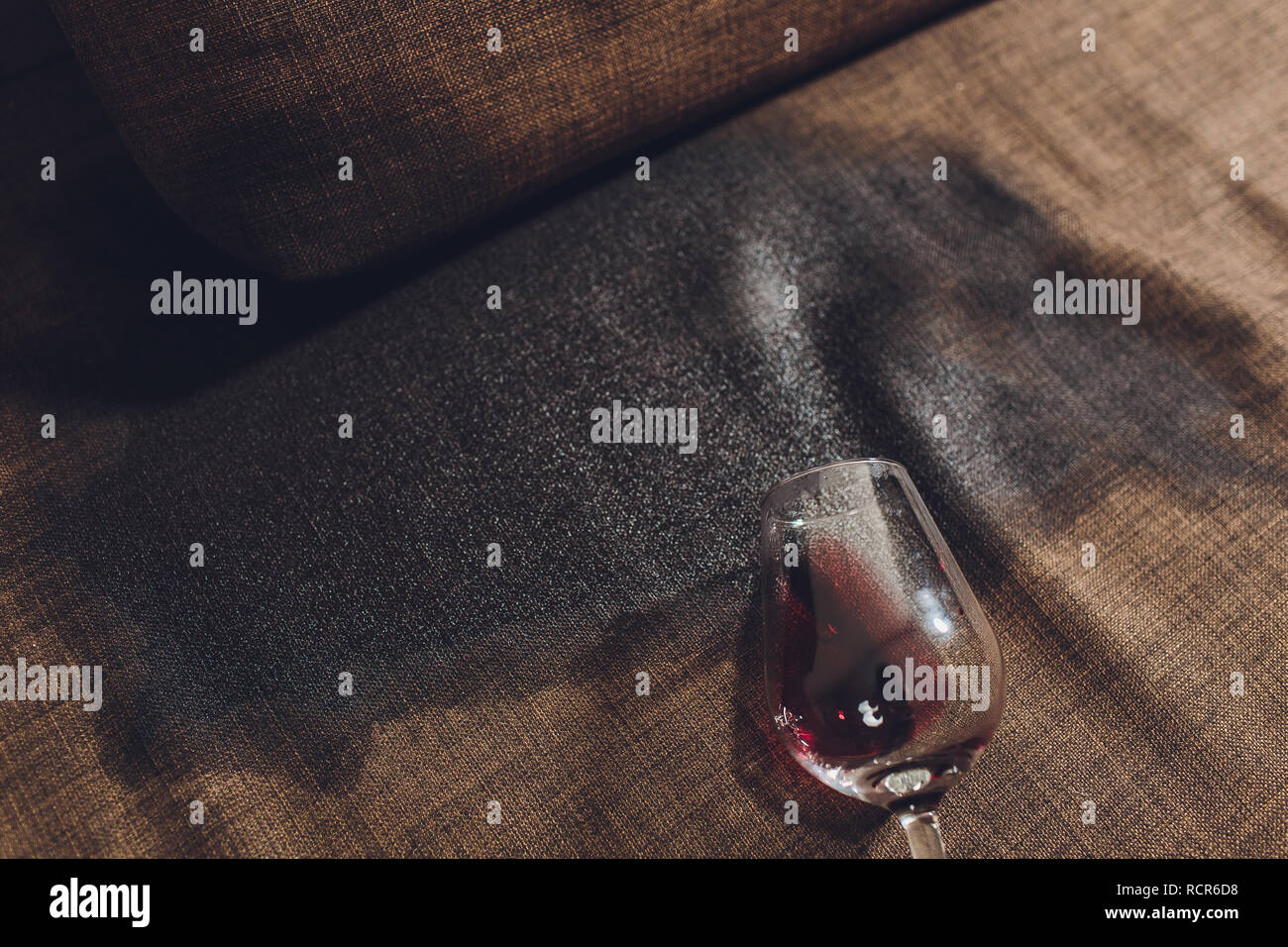Red wine spilled on a grey couch sofa Stock Photo - Alamy