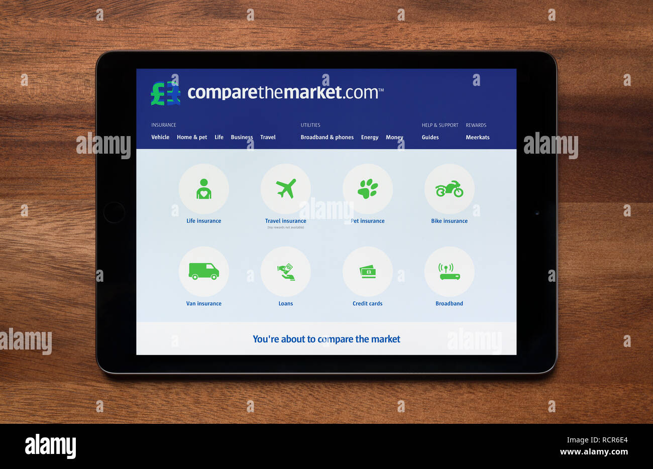 The website of Compare The Market is seen on an iPad tablet, which is resting on a wooden table (Editorial use only). Stock Photo