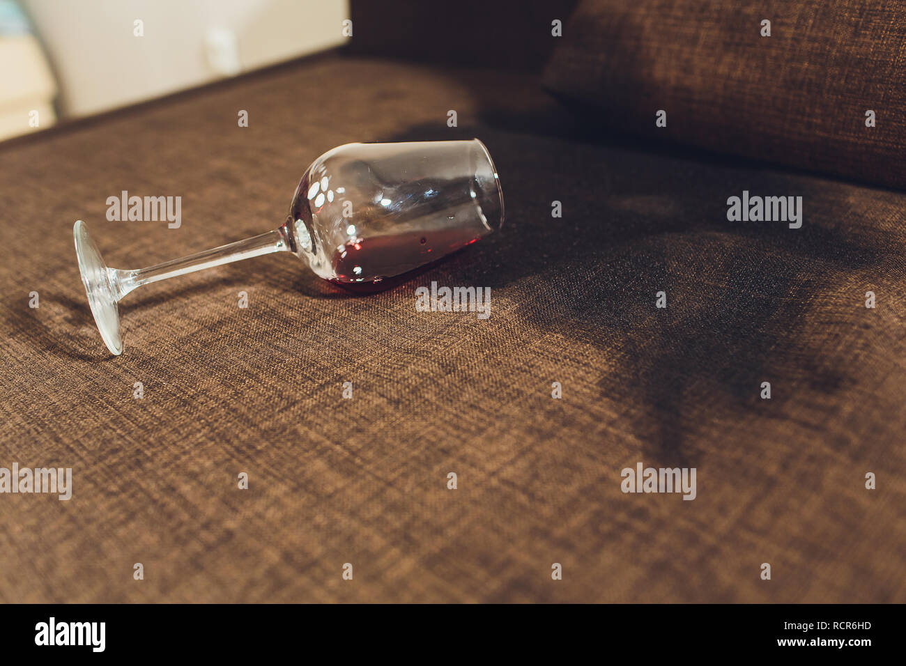 Red wine spilled on a grey couch sofa Stock Photo - Alamy