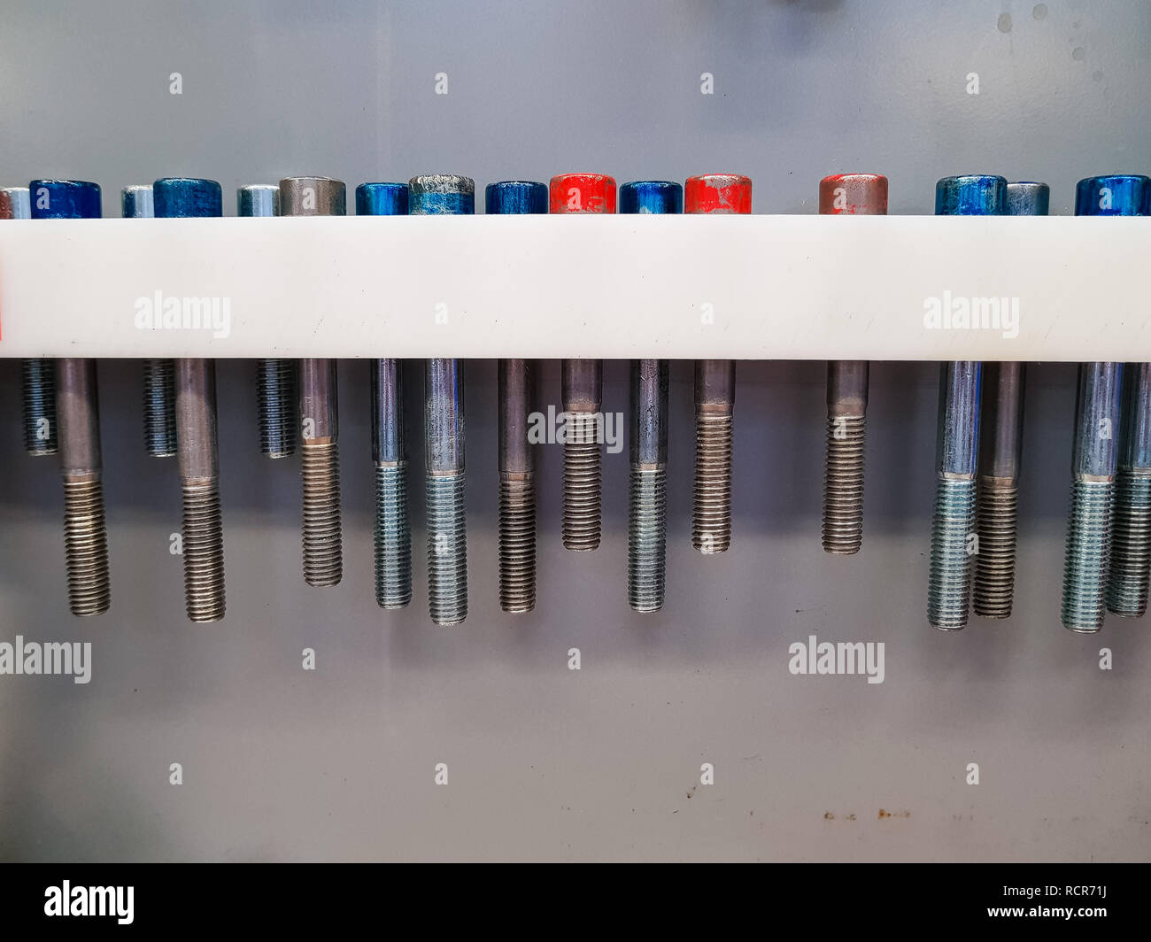 A white shelf custom made for screws of different length Stock Photo