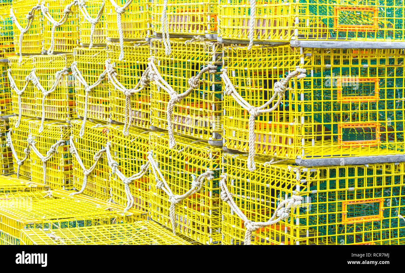bright yellow empty lobster traps stacked up on a fishing wharf in