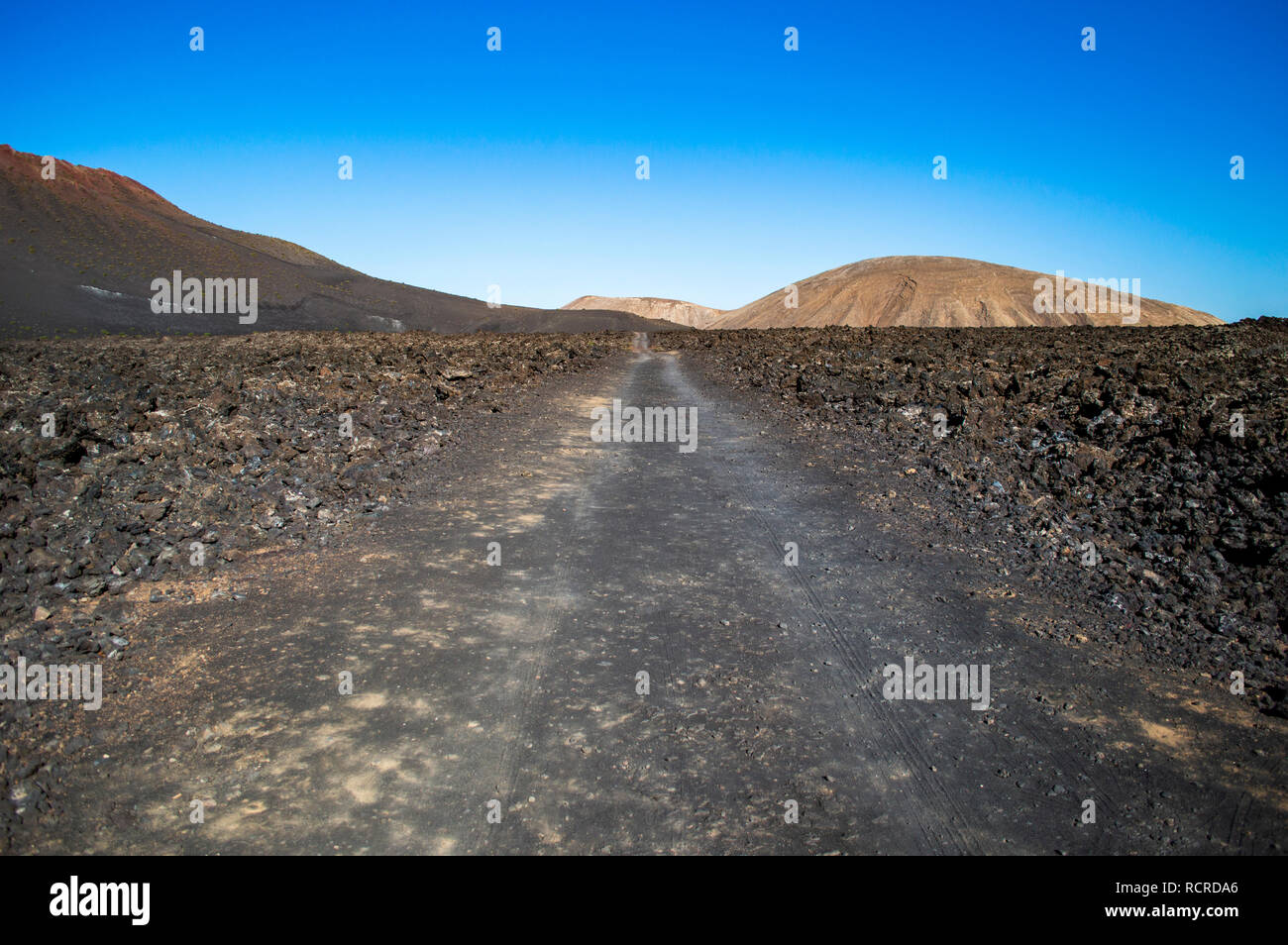 A track leading to the coast in Timanfaya National Park in Lanzarote, Canary Islands Stock Photo