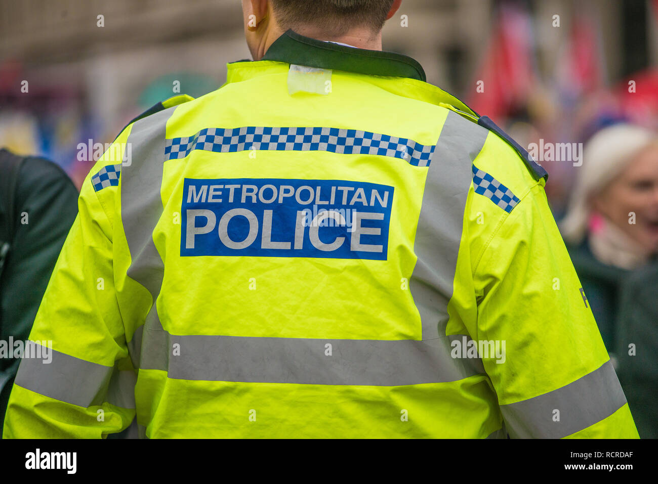 Metropolitan Police sign on the back of a high visibility jacket worn by police officers escorting a street demonstration through central London, UK. Stock Photo