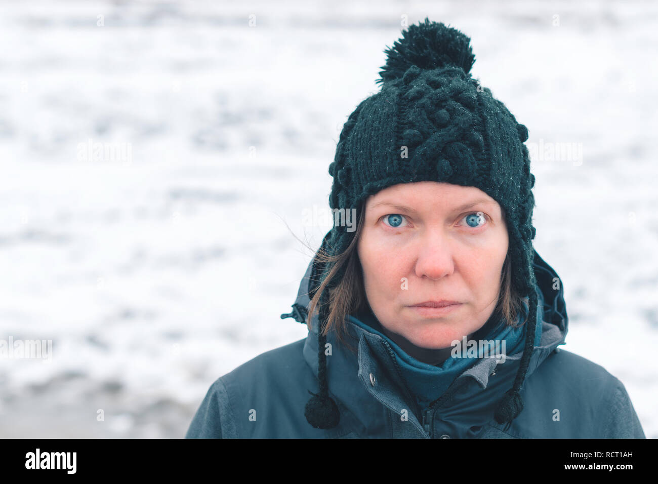 Portrait of concerned adult caucasian woman standing in snowy outdoors Stock Photo