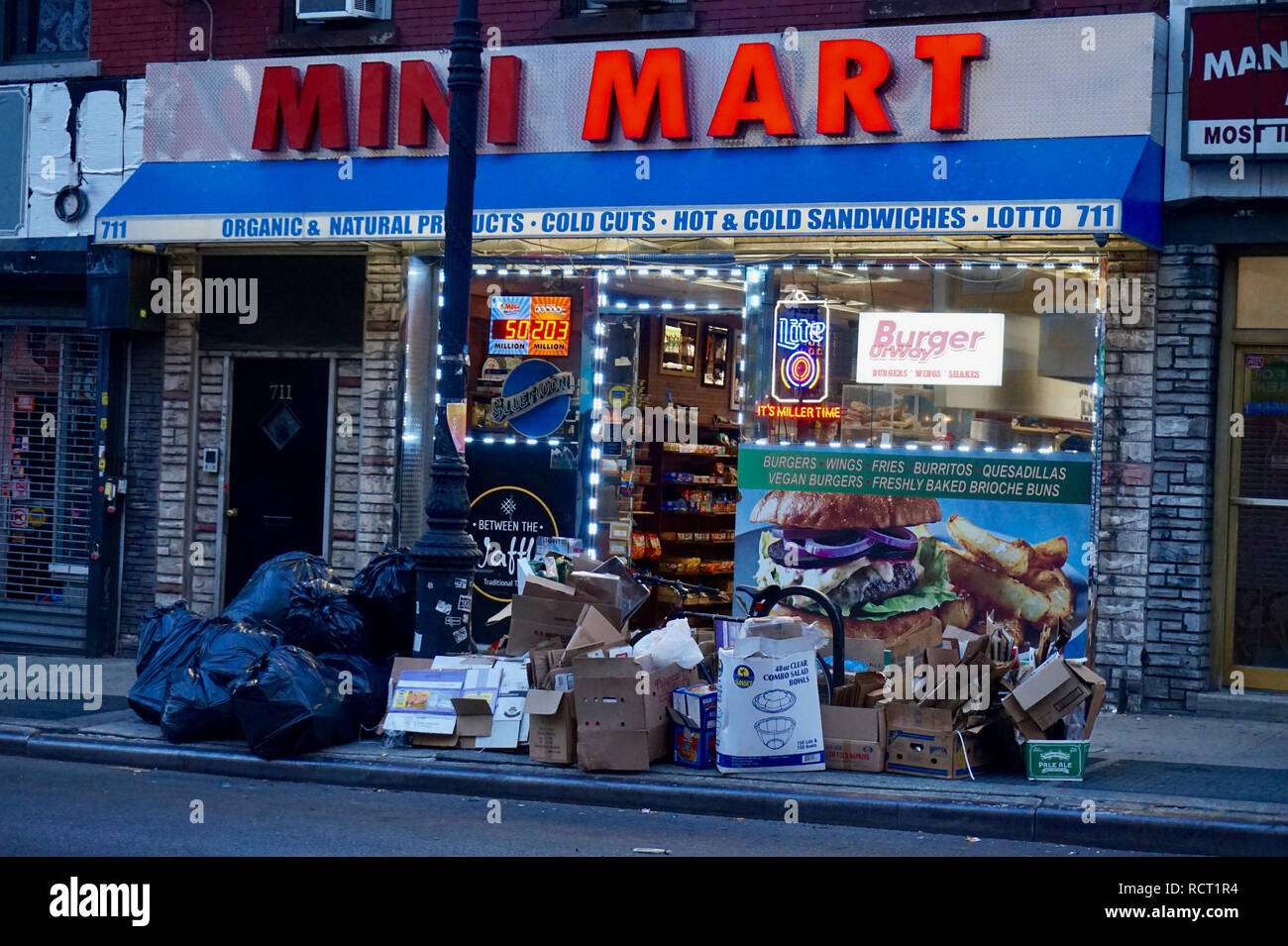 Garbage piled outside on the sidewalk in Brooklyn, New York, next to a retail store Stock Photo