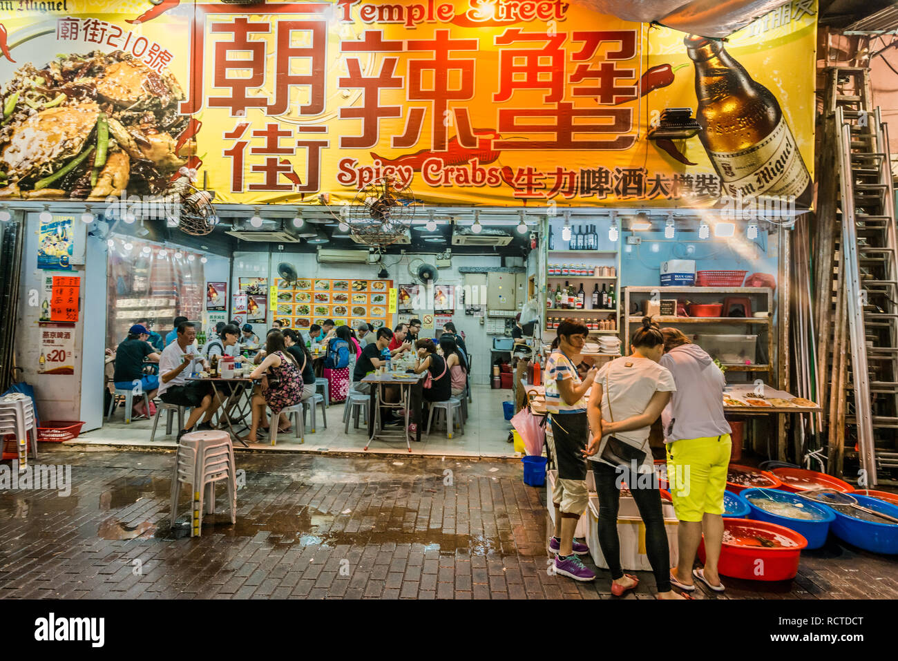 Kowloon, Hong Kong, China- June 8, 2014: people outside seafood restaurants in the Temple street night market Tsim Sha Tsui Stock Photo