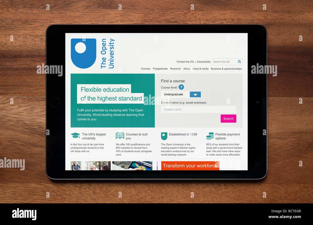 The website of Open University is seen on an iPad tablet, which is resting on a wooden table (Editorial use only). Stock Photo