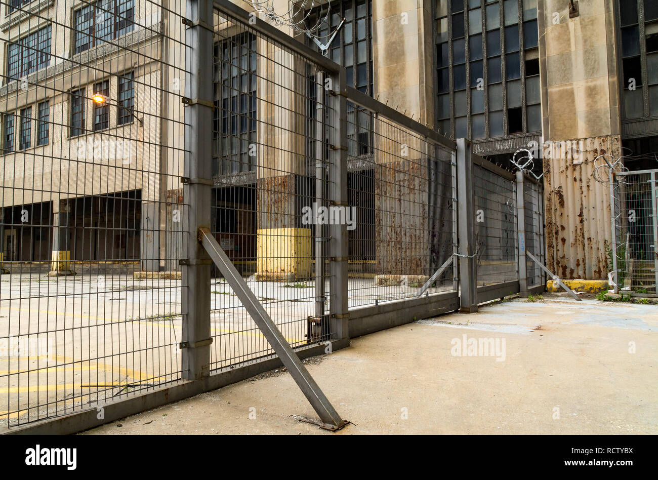 Industrial metal gate with abandoned building in background. Chicago