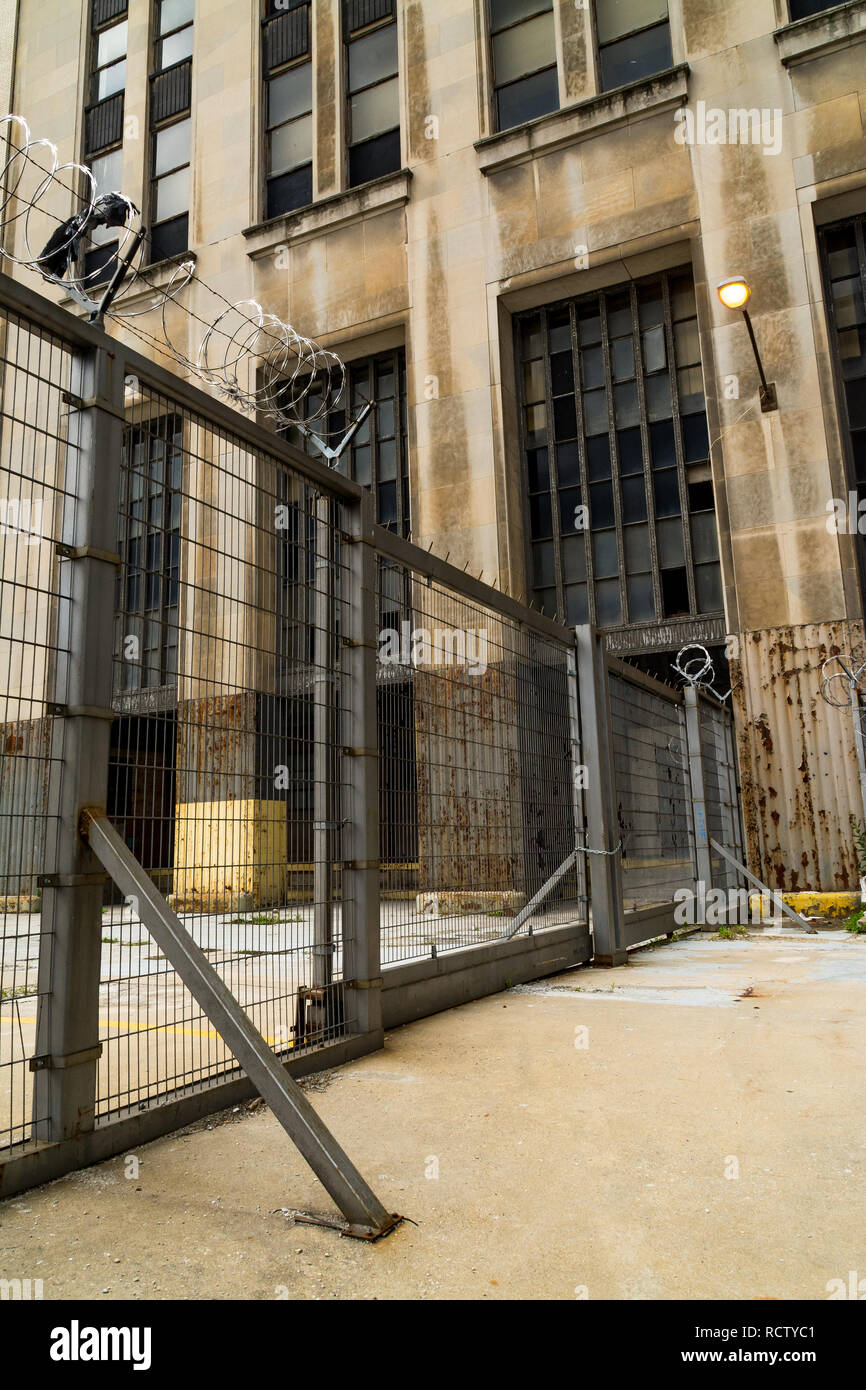 Industrial metal gate with abandoned building in background. Chicago
