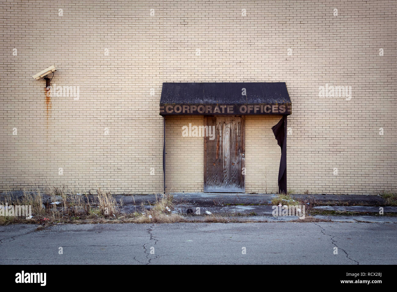 Boarded up doorway with awning labeled corporate offices. Stock Photo