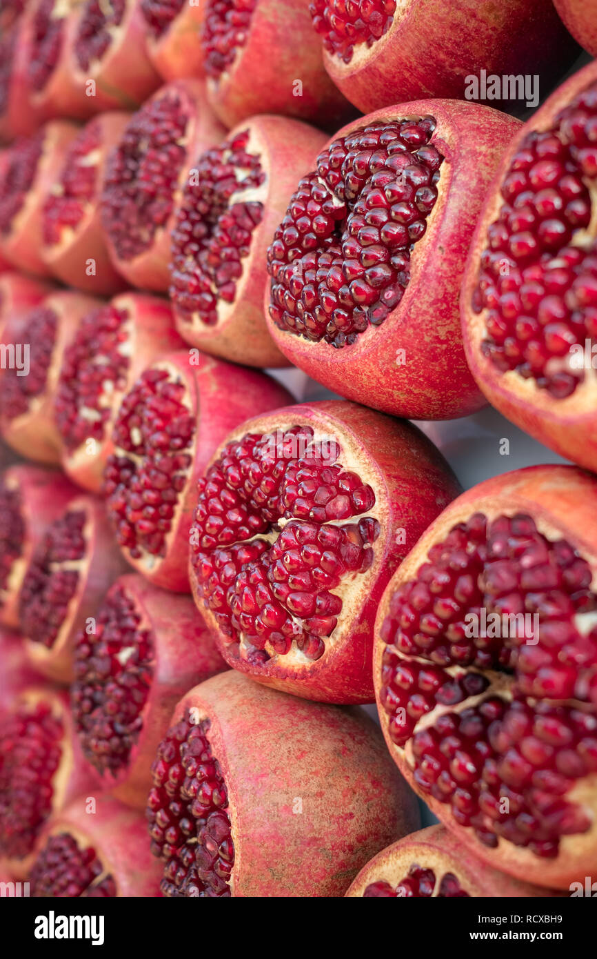 Ripe and juicy half peeled pomegranates ready to be squeezed for fresh juice. Close up view Stock Photo