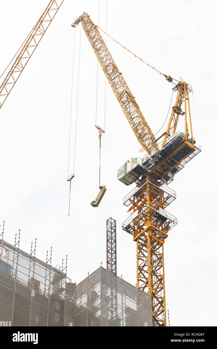 Construction cranes at work to construct a tall building in Bangkok Stock Photo