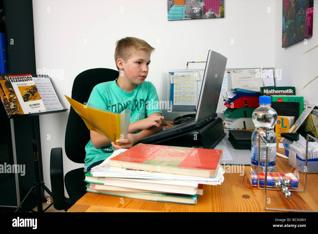 Boy, 12 years, doing his homework in his room, studying for school Stock Photo
